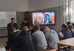 Uczniowie w sali oglądają prezentację multimedialną na ekranie