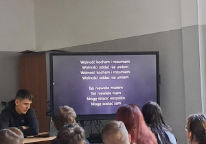 Uczniowie w sali oglądają prezentację multimedialną na ekranie