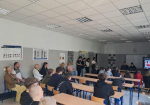 Uczniowie w sali oglądają prezentację multimedialną na ekranie